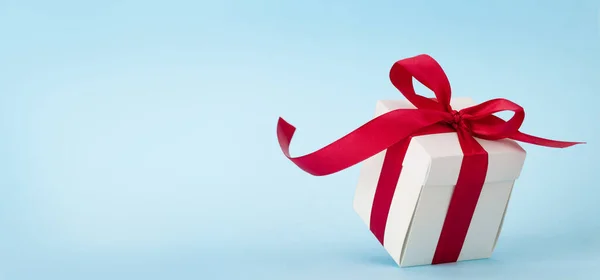 Λευκό Κουτί Δώρου Κόκκινη Κορδέλα Πάνω Από Μπλε Φόντο Χώρο — Φωτογραφία Αρχείου