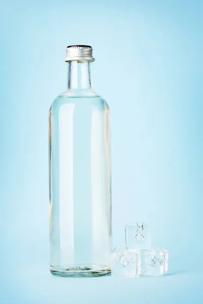 Botella Agua Vidrio Cubitos Hielo Sobre Fondo Azul — Foto de Stock