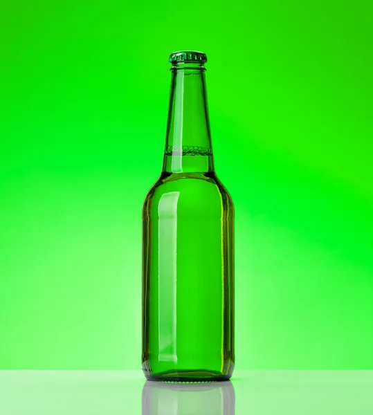 緑の背景の前にビールボトル スタジオショット — ストック写真