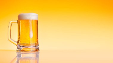 Sarı arka planda bira bardağı. Kopyalama alanı ile stüdyonun görüntüsü
