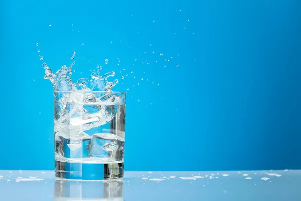 Water Glass Ice Cubes Splash Blue Background Copy Space — Stock Photo, Image
