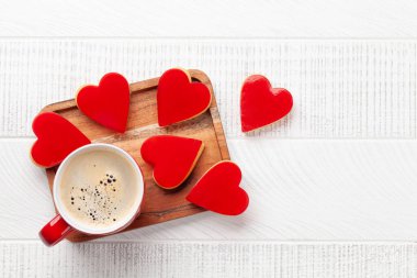 Kalp şeklinde tatlı kurabiyeler ve kahve fincanı. Sevgililer Günü tebrik kartı. Üst görünüm düzlüğü kopyalama alanı ile yatıyordu