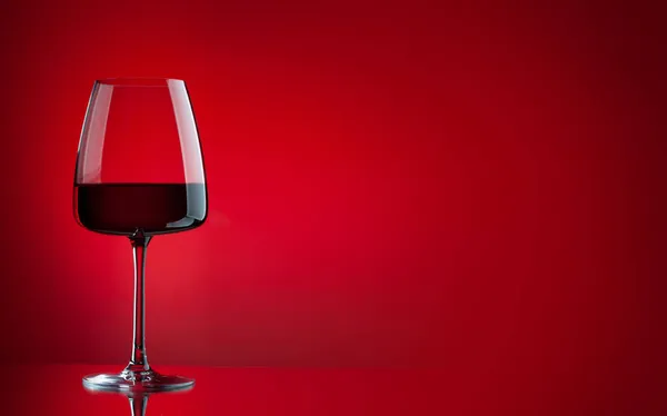 Rött Vin Glas Över Röd Bakgrund Med Kopieringsutrymme — Stockfoto