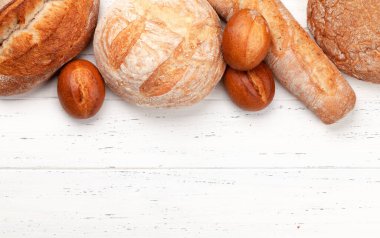 Tahta masada çeşitli ekmek türleri. Üst görünüm düzlüğü kopyalama alanı ile yatıyordu