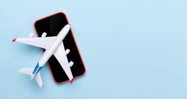 Seyahat ve tatil konsepti. Aksesuarlar ve eşyalar. Akıllı telefondan uçak oyuncağı. Üst görünüm düzlüğü kopyalama alanı ile yatıyordu