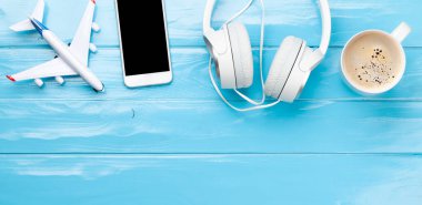Seyahat ve tatil konsepti. Aksesuarlar ve eşyalar. Uçak oyuncağı ve akıllı telefon. Üst görünüm düzlüğü kopyalama alanı ile yatıyordu