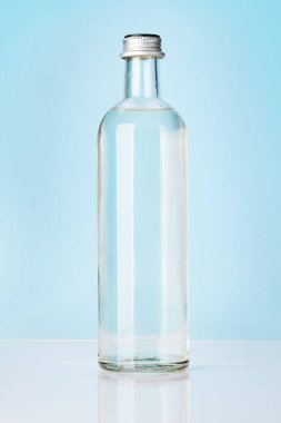 Mavi arka planda cam su şişesi