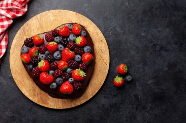Kalp şeklinde böğürtlenli tatlı kek. Sevgililer Günü tebrik kartı. Üst görünüm düzlüğü kopyalama alanı ile yatıyordu