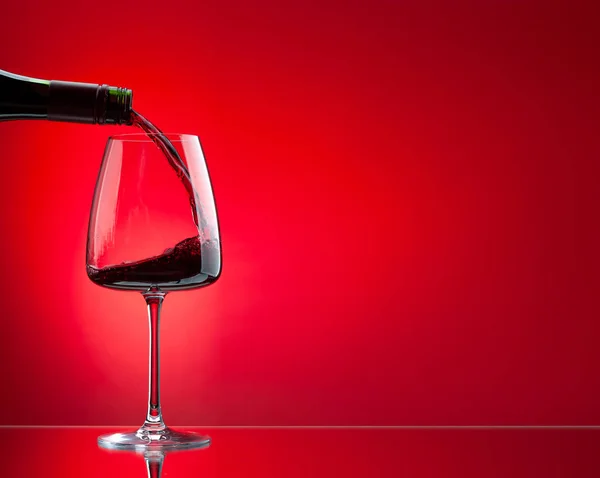 Vin Rouge Versé Bouteille Dans Verre Sur Fond Rouge — Photo