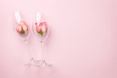 Gül çiçekli şampanya kadehleri. Sevgililer Günü tebrik kartı. Selamlarınız için yer var. Üst görünüm düzlüğü