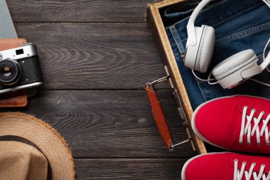 Seyahat ve tatil konsepti. Eşyaları ve kıyafetleri olan bir valiz. Üst görünüm düzlüğü kopyalama alanı ile yatıyordu