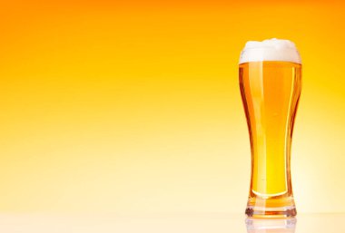 Sarı arka planda bira bardağı. Kopyalama alanı ile stüdyonun görüntüsü