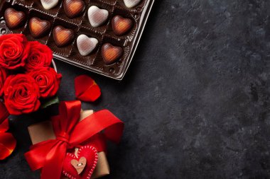 Gül çiçekleri ve kalp şeklinde şekerler. Sevgililer Günü tebrik kartı, hediye paketi ve selamlarınız için yer. Üst görünüm düzlüğü