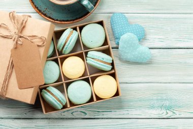 Hediye kutusu ve kahve fincanında ev yapımı kurabiyeler. Üst görünüm düzlüğü kopyalama alanı ile yatıyordu