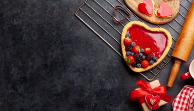 Böğürtlenli, kurabiyeli ve hediye kutulu kalp şeklinde tatlı pasta. Sevgililer Günü tebrik kartı. Üst görünüm düzlüğü kopyalama alanı ile yatıyordu