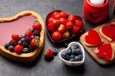 Kalp şeklinde tatlı kek, böğürtlen ve kurabiye. Sevgililer Günü tebrik kartı.