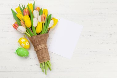 Paskalya tebrik kartı, üzerinde paskalya yumurtaları ve lale çiçekleri var. Üst görünüm düzlüğü kopyalama alanı ile yatıyordu