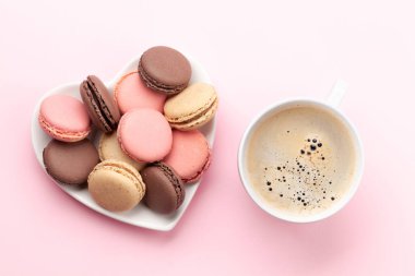 Sevgililer Günü 'nde kalp şeklindeki kurabiyeler ve pembe arka planda kahve fincanı. Üst görünüm düzlüğü