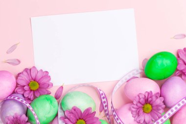 Renkli paskalya yumurtaları ve çiçeklerle dolu Paskalya tebrik kartı. Tebrik etmek için en üstteki dairede yer var.