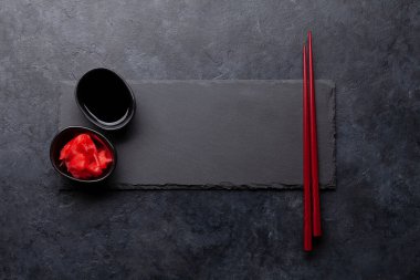 Suşin ve makin için taş tabak ve çubuk. Japon yemek menüsü arka planı. Üst görünüm düzlüğü kopyalama alanı ile yatıyordu
