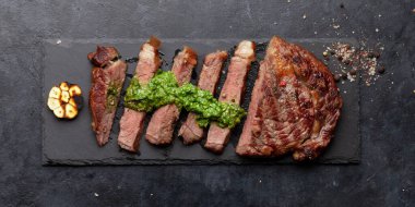 Sos ile dilimlenmiş biftek. Taş tahtada. Üst görünüm düzlüğü