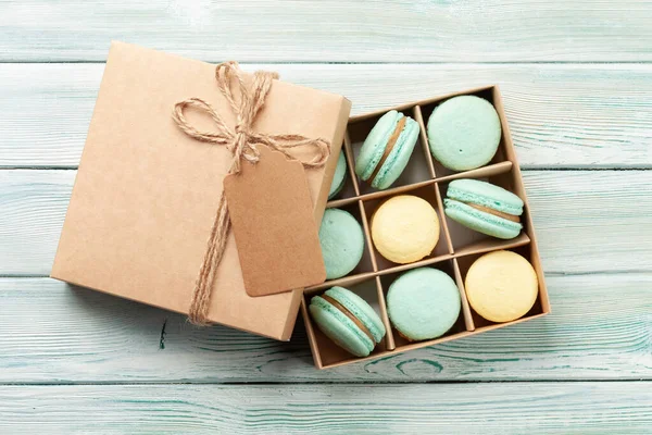 Homemade macaroons in gift box and coffee cup. Top view flat lay with copy space