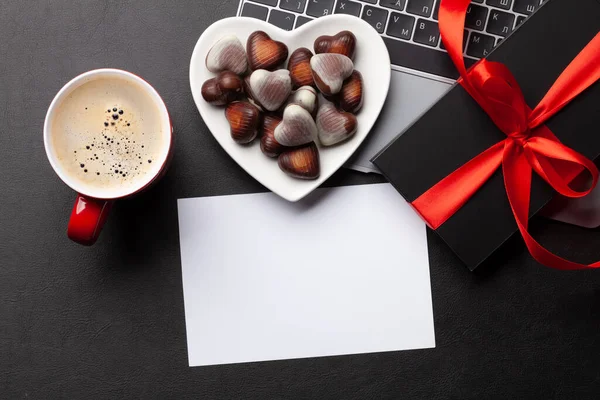 オフィスの机のテーブルでラップトップ上のギフトボックスとチョコレートの心のお菓子 あなたの挨拶のための空白のグリーティングカードでトップビューフラットレイ バレンタインデーテンプレート — ストック写真