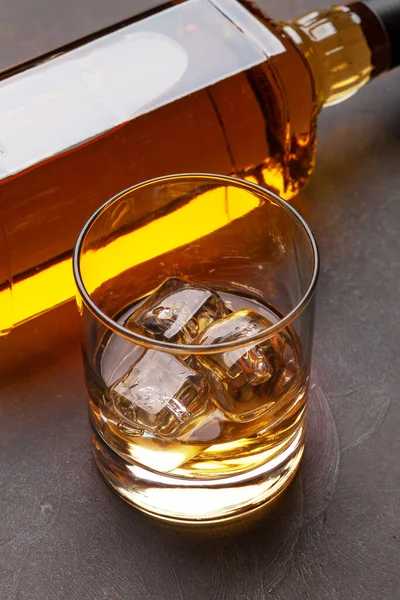 苏格兰威士忌瓶和玻璃杯放在石桌上 — 图库照片