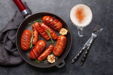 Kızartma tavasında ızgara sosis, sarımsak ve biberiyeli. Üst görünüm düzlüğü