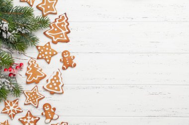 Zencefilli kurabiye ve köknar ağacıyla dolu tebrik kartı. Tahta masaya uzan ve yılbaşı kutlamaların için yer aç.