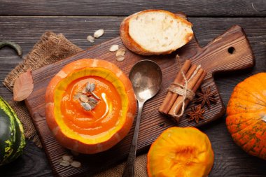 Balkabağı kremalı çorba ve çeşitli renkli kabaklar ve balkabakları. Sonbahar sebze hasadı. Üst görünüm düzlüğü