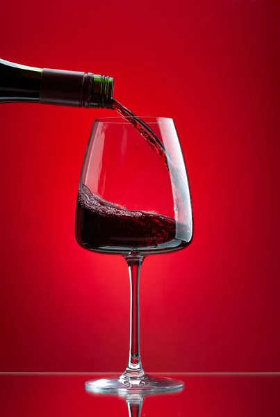 Vin Rouge Versé Bouteille Dans Verre Sur Fond Rouge — Photo