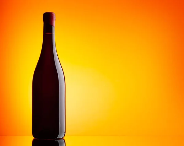 Czerwona Butelka Wina Pomarańczowym Tle Miejscem Kopiowania — Zdjęcie stockowe