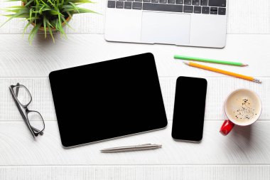 Tablet ve akıllı telefon. Masasında boş ekran var. Üst görünüm düzlüğü kopyalama alanı ile yatıyordu