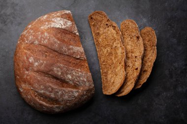 Taş masada ev yapımı taze ekmek dilimlenmiş. Kopyalama alanı olan düz