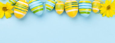 Paskalya tebrik kartı, içinde paskalya yumurtaları ve çiçekler var. Üst görünüm düzlüğü kopyalama alanı ile yatıyordu