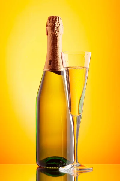 Champagne Glas Och Mousserande Vin Flaska Över Gul Bakgrund — Stockfoto