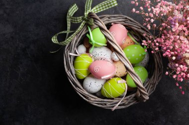 Paskalya tebrik kartı, içinde paskalya yumurtaları ve çiçekler var. Üst görünüm düzlüğü kopyalama alanı ile yatıyordu