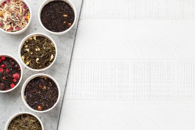 Çeşitli kurutulmuş çaylar. Bitki, yeşil ve siyah çay yaprakları. Üst görünüm düzlüğü kopyalama alanı ile yatıyordu