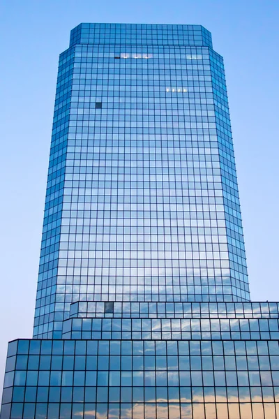 Bâtiment en verre bleu avec reflet ciel et nuages — Photo