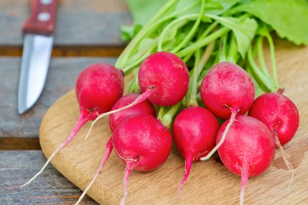 Fresh radishes on a wooden cutting board — Stock Photo, Image