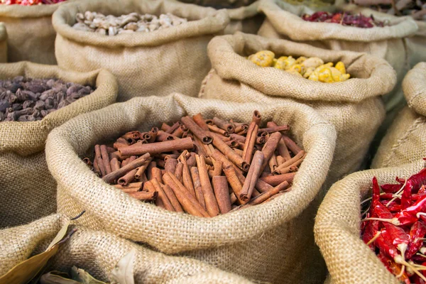 Canela y otras especias en las bolsas en el mercado indio — Foto de Stock