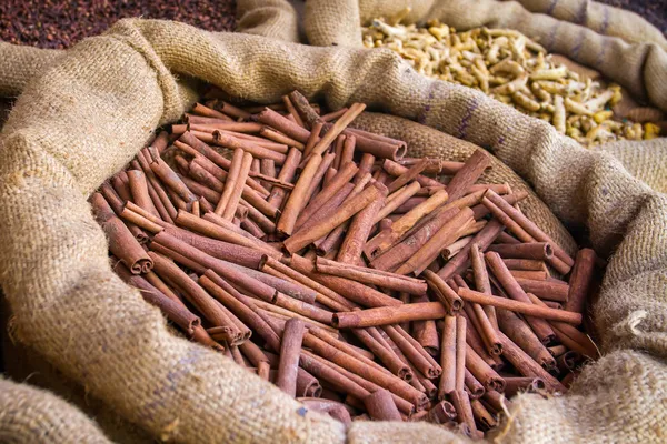 Canela e outras especiarias nos sacos no mercado indiano — Fotografia de Stock