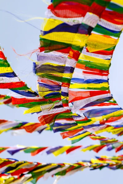 Banderas budistas tibetanas de oración contra el fondo azul del cielo —  Fotos de Stock