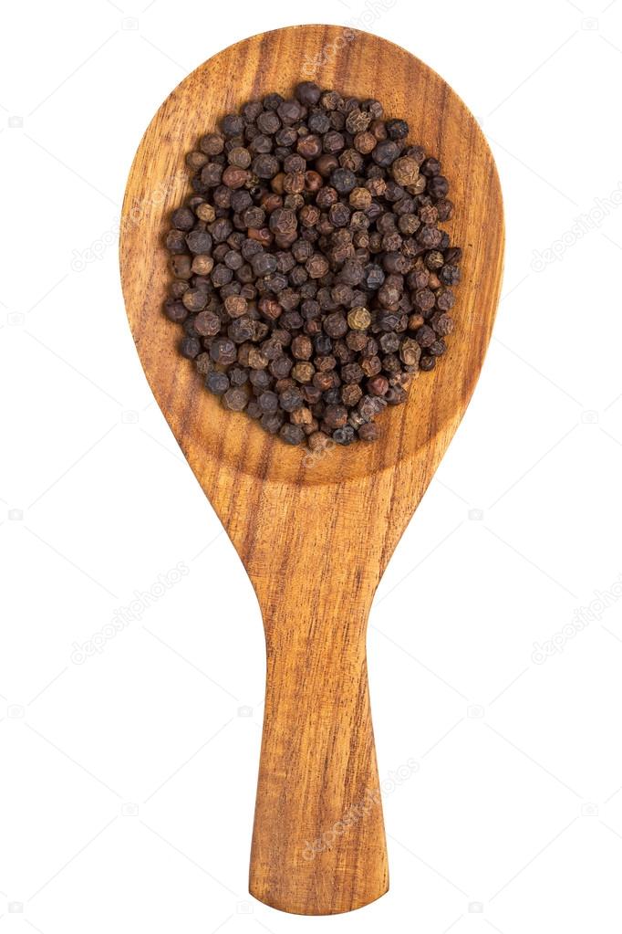 Black pepper (Piper nigrum) peppercorns in the wooden spoon