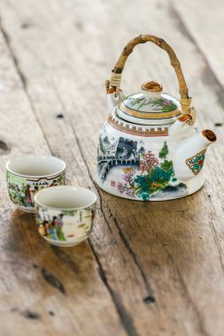 Çin porselen çaydanlık ve ahşap bir masa üstünde iki bardak
