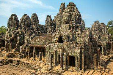 Stone faces on the towers of ancient Bayon Temple in Angkor Thom clipart
