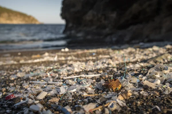 Pequenas peças de plástico e microplásticos na praia de areia — Fotografia de Stock
