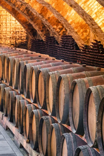 Velhos barris de madeira com vinho nas antigas caves medievais — Fotografia de Stock