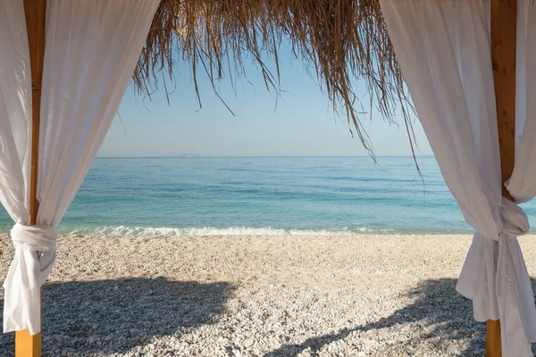 Fedett tengerparti ágy fehér függönyökkel a homokos tengerparton — Stock Fotó
